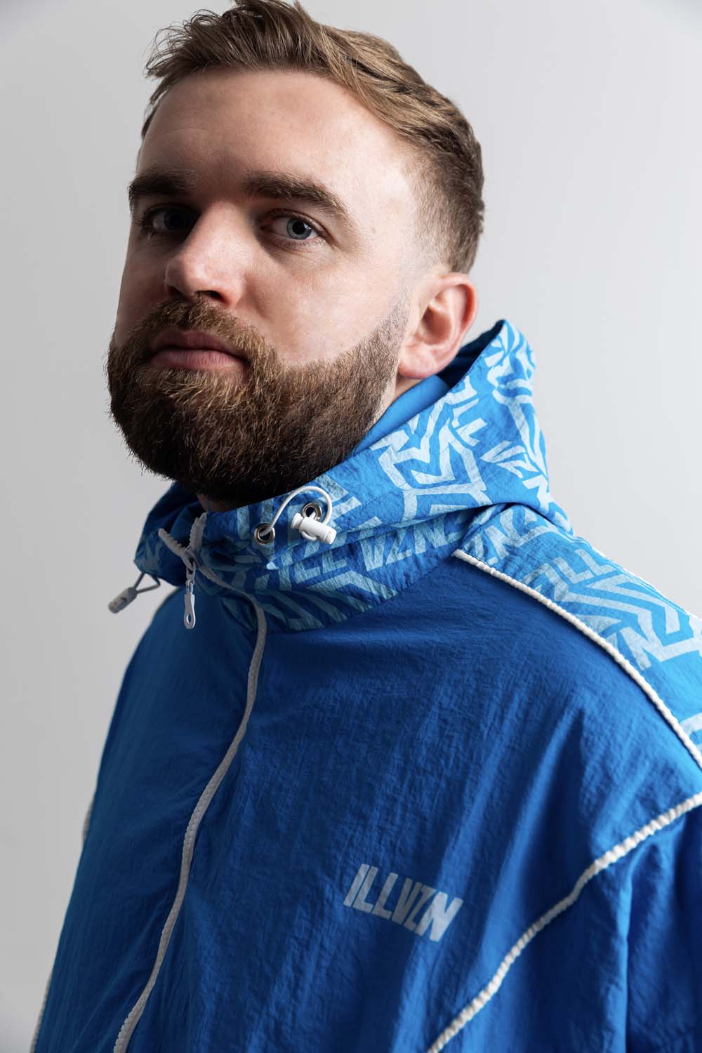 Gaskin wearing a blue jacket with a brand logo on a plain background