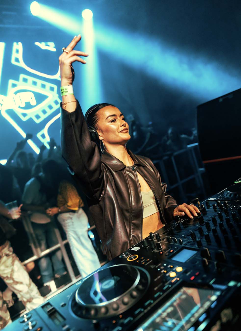 DJ at a concert with crowd and lights in the background
