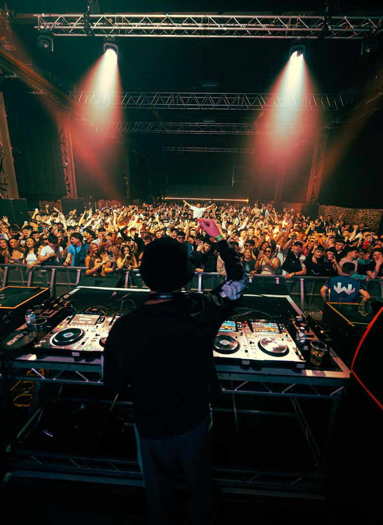DJ at a concert with a crowd and stage lights