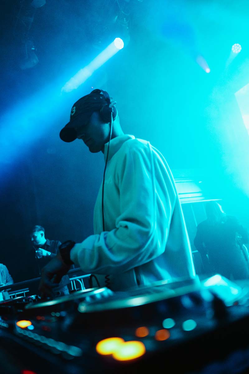 DJ performing at a concert with blue lighting