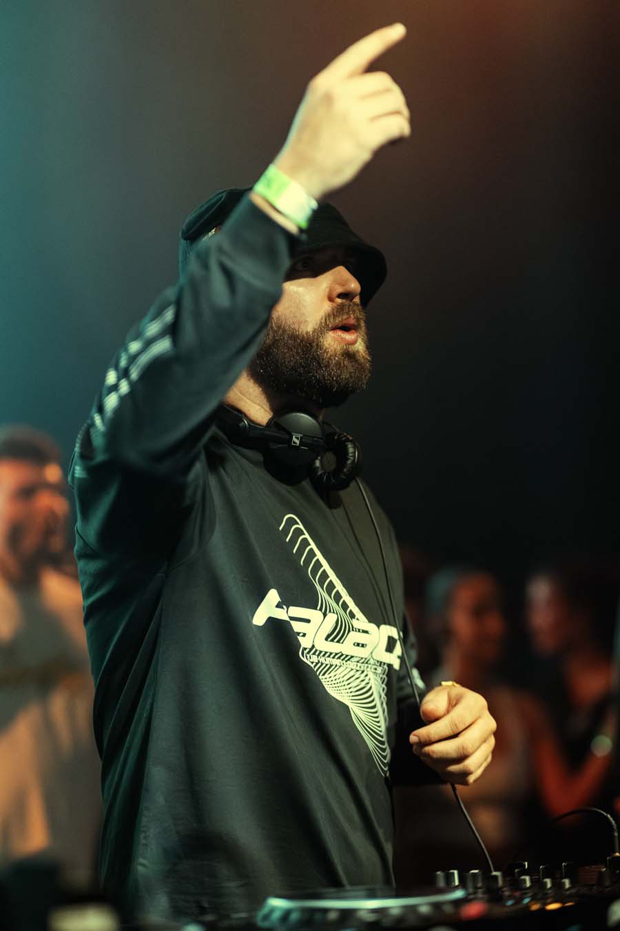 DJ performing on stage with a crowd in the background
