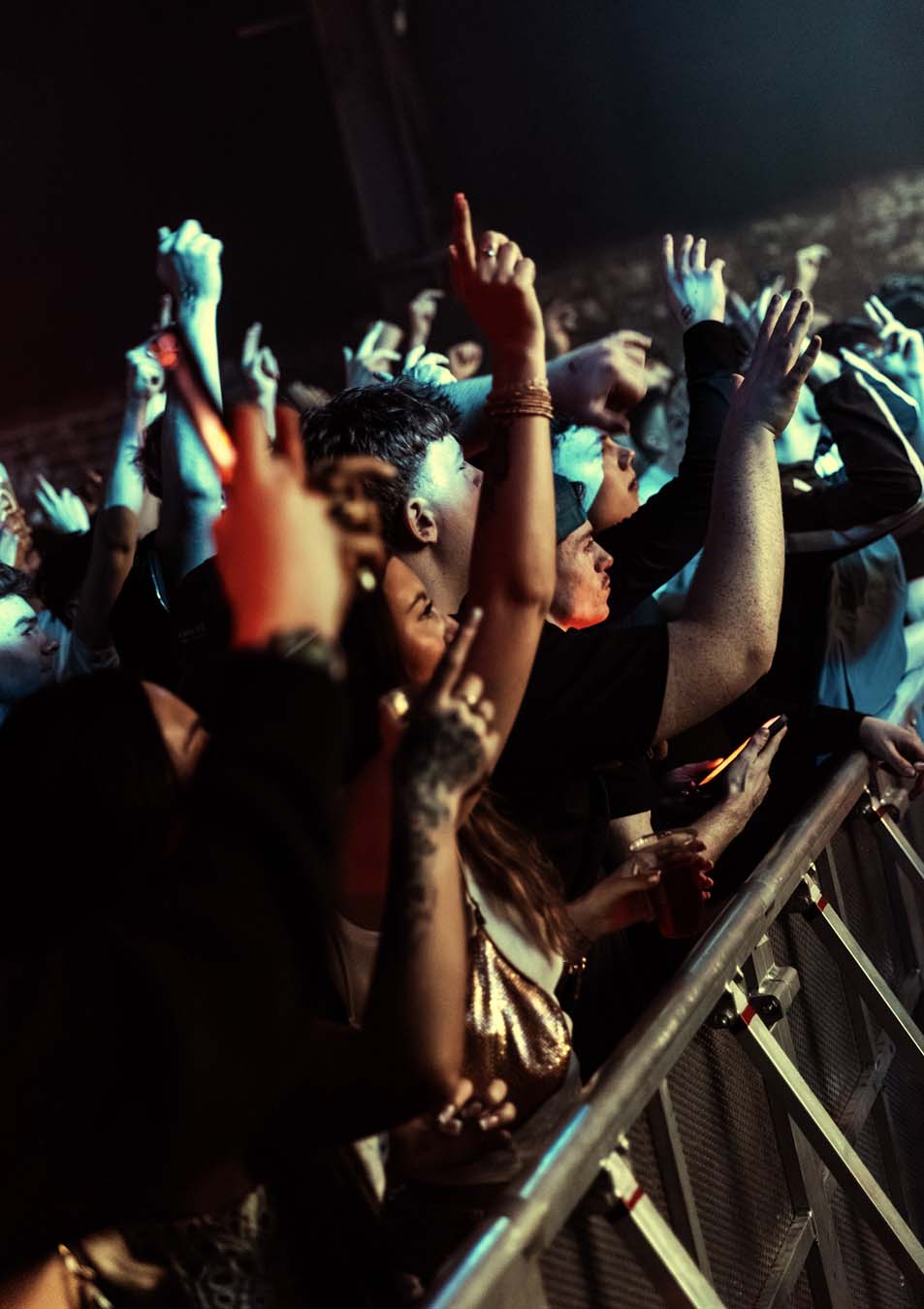 People at a concert with raised hands in the air